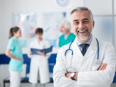 Confident,Smiling,Doctor,Posing,And,The,Hospital,With,Arms,Crossed